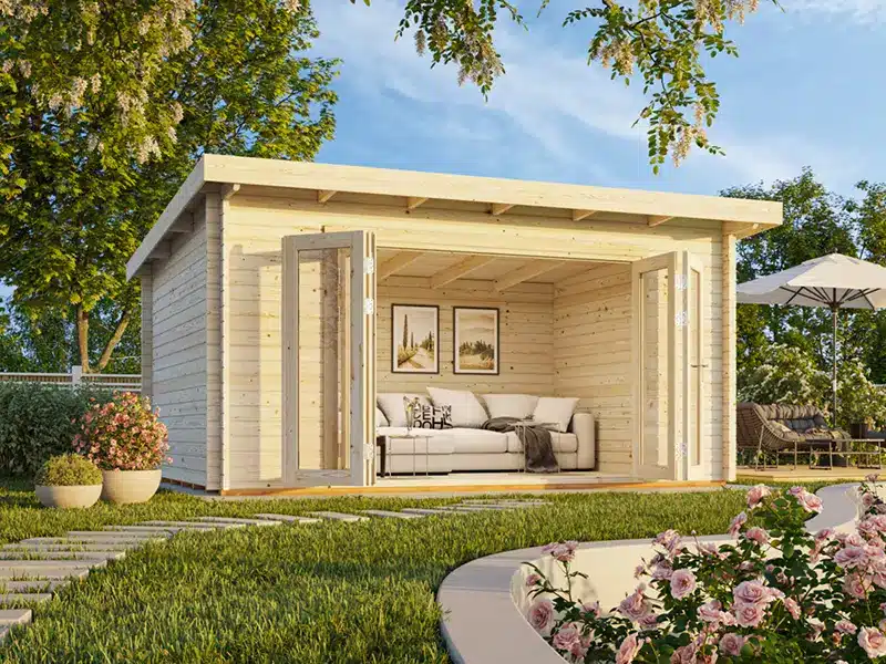 Abris de jardin en bois avec espace salon à l’intérieur et terrasse attenante.