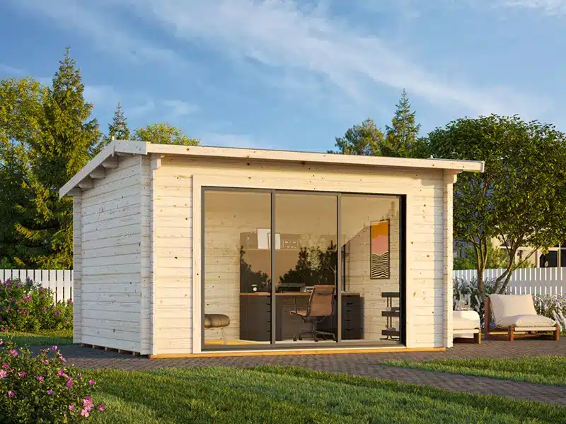 Petit chalet de jardin en bois blanc, avec façade vitrée et porte coulissante, sur une pelouse entourée d’arbres.