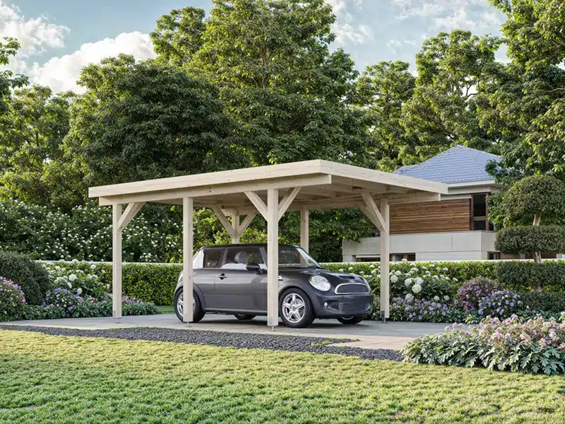 Voiture garée sous un carport en bois moderne avec poutres apparentes, dans un jardin arboré.